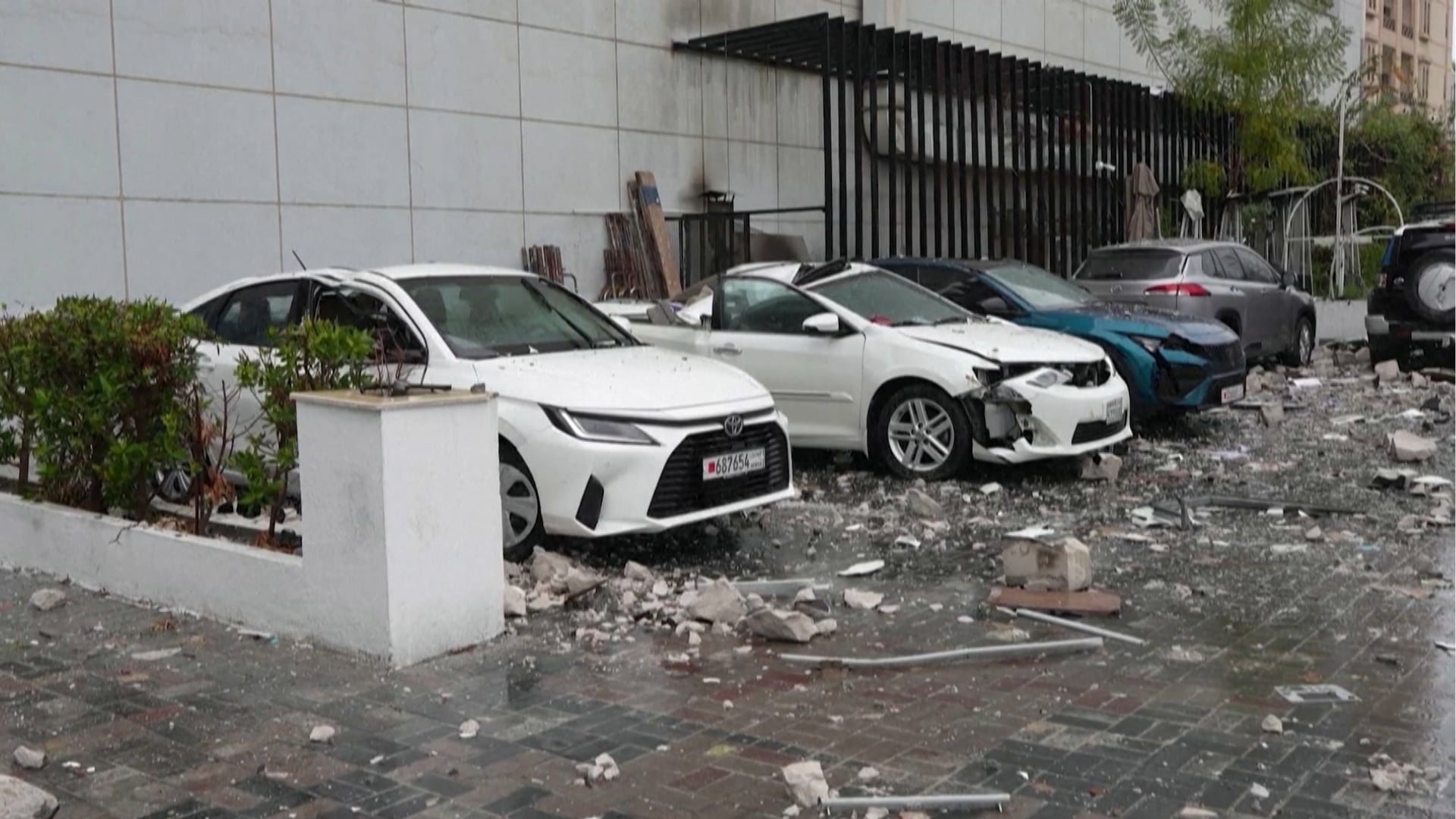 Carros enfileirados, em meio aos destroços de explosão