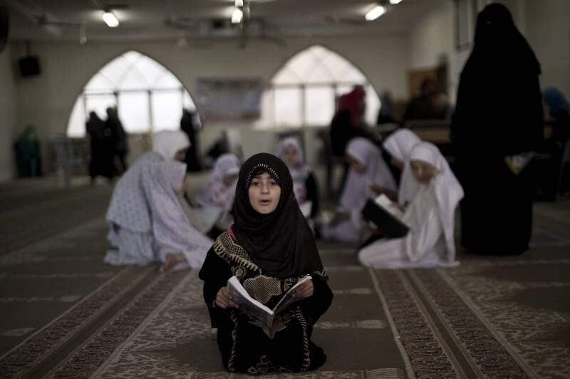 Menina palestina estuda o Corão, livro religioso islâmico,
durante acampamento de férias organizado pelo Hamas, na Faixa de Gaza