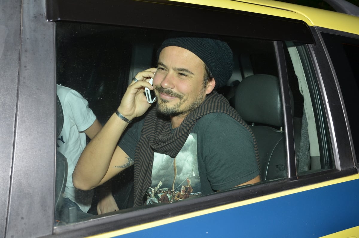 Paulinho Vilhena chegou de taxi e falava ao telefone quando foi abordado por fotógrafos