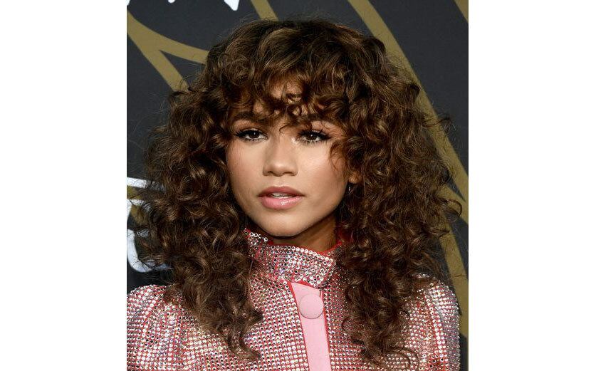 No time das cacheadas gringas, Zendaya é mais uma a apostar no corte em camadas e na franja cacheada, que dá um toque ainda mais ousado ao visual