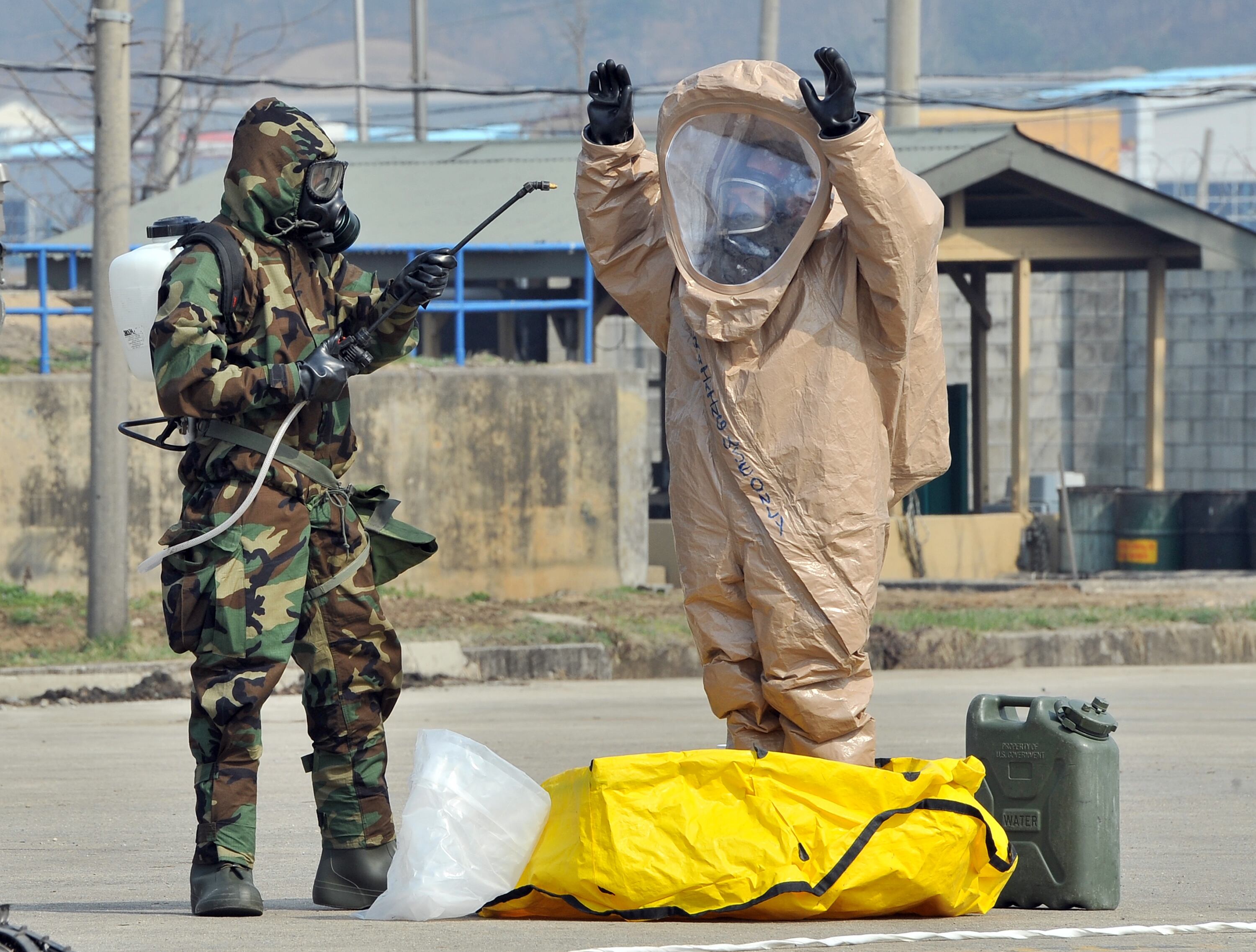 Soldados mostram como é feito o processo de descontaminação de roupa atingida por armas químicas ou biológicas