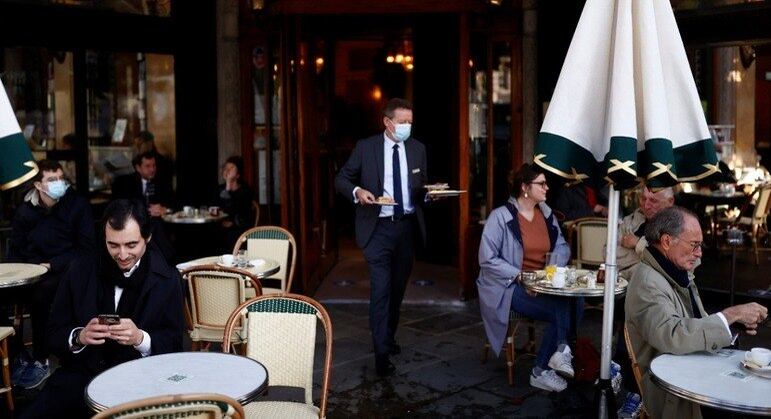 Clientes em um café da cidade no dia da reabertura