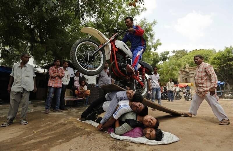  

Devoto hindu faz acrobacias de moto durante ensaio para o
festival anual Rath Yatra em Ahmedabad,
na Índia
